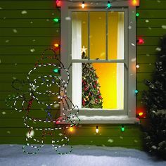 a christmas tree is seen through an open window