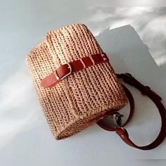 a handbag sitting on top of a white surface