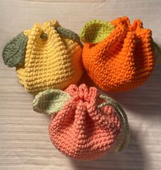 three crocheted bags sitting on top of a table