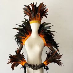 a white mannequin with orange and black feathers on it