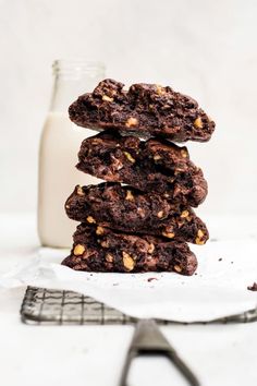 chocolate cookies stacked on top of each other next to a glass of milk