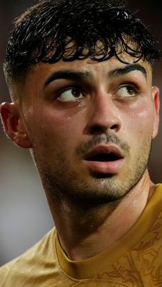 a close up of a soccer player looking at the camera with an intense look on his face