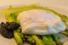 asparagus with sour cream and black truffle on a white dinner plate