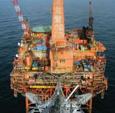 an oil rig in the middle of the ocean with lots of equipment on top of it