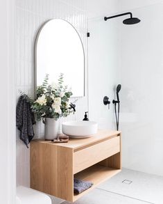 a bathroom with a sink, mirror and shower head in it's center piece