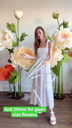 a woman standing in front of large flowers