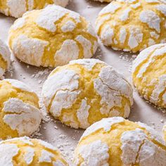 freshly baked powdered sugar cookies sitting on top of a baking sheet covered in water droplets