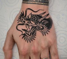 a hand with a dragon tattoo on it