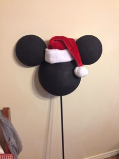 a mickey mouse head with a red santa hat on it's head is mounted to the wall