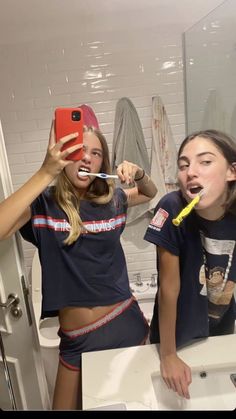 two girls brushing their teeth in the bathroom