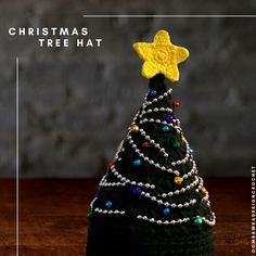 a crocheted christmas tree hat with a star on top and beads around the base