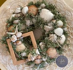 a white doily topped with a wreath and seashells