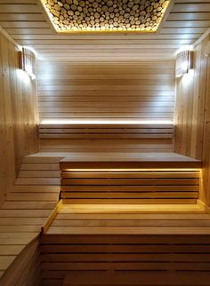 the inside of a sauna with wooden benches and lights