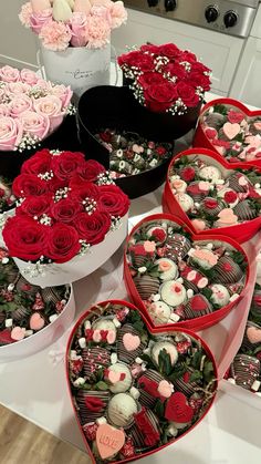 several heart shaped boxes filled with roses and chocolates on a table in a kitchen