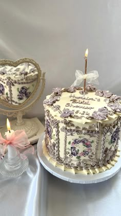 there is a cake that has been decorated with flowers on it and two candles in the middle