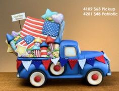 a blue truck filled with lots of items on top of a wooden table next to a brown wall