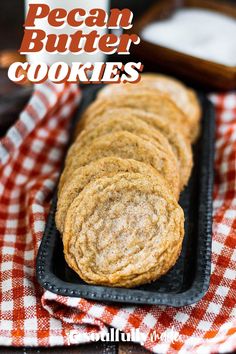 some cookies are on a black tray and red checkered cloth with the words, pecan butter cookies