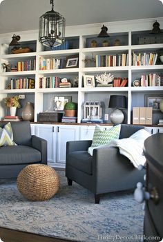 a living room filled with furniture and bookshelves covered in lots of bookcases