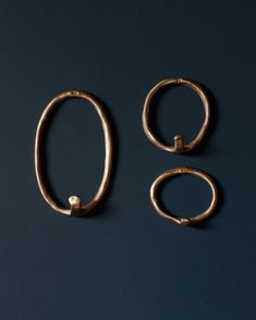 three pairs of gold rings on a blue surface with one ring attached to the other