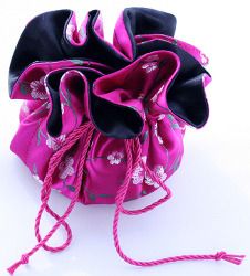 a pink and black bag sitting on top of a white table