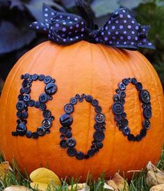 an orange pumpkin with the word diy spelled out on it in black beads and a bow