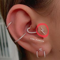 a woman wearing ear piercings with the word gabi piercer on it