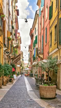 a cobblestone street lined with buildings and tables