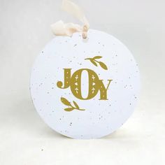 a white ornament with the word joy on it's front and bottom