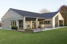 a house that is in the middle of some grass and has windows on each side