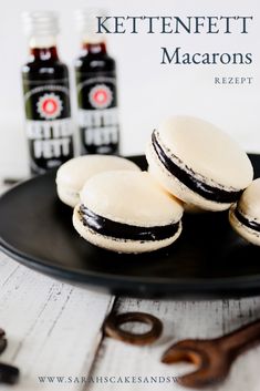 three macarons on a plate with two bottles of ketchup in the background