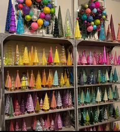 there are many different colored vases on the shelves