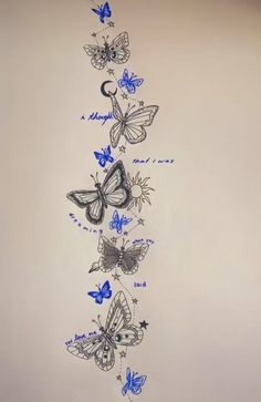 a drawing of butterflies on a white wall with blue writing in the bottom right corner