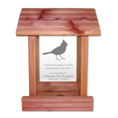 a bird is sitting on top of a wooden stand with a plaque in it's center