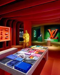 a table with many books on it in a room filled with red and green walls