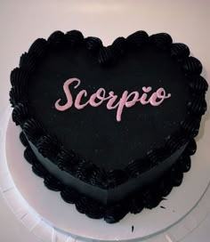 a black heart shaped cake with the word scoppo on it's side