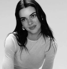 a black and white photo of a woman with big hoop earrings on her head, posing for the camera