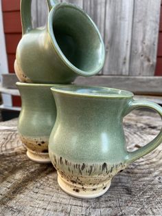 two green cups sitting on top of a wooden table