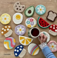 a person is holding a cup in front of some crocheted coasters