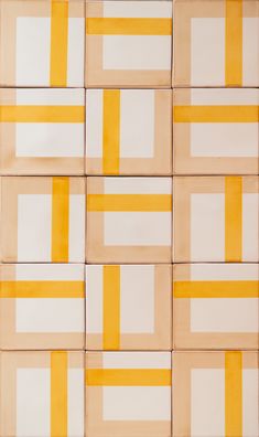 yellow and white squares are arranged in an abstract pattern on the wall, as if they were painted with acrylic paint