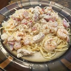 pasta with shrimp and parmesan cheese in a bowl