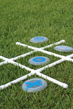 several white and blue frisbees sitting on top of the grass in front of each other