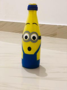 a yellow and blue bottle sitting on top of a counter next to a white wall