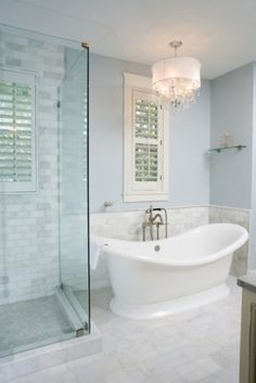 a white bath tub sitting next to a walk in shower