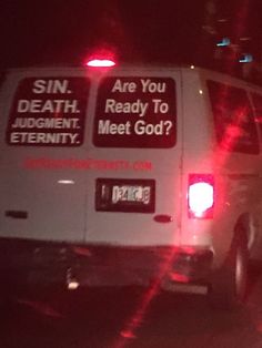 a van with some stickers on it driving down the street at night time in the dark