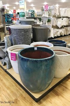 there are many pots on display in the store