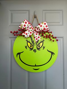 a green door with a grin face and red polka dot bows on it's head