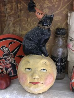 an assortment of halloween decorations including pumpkins and cats on top of a carved moon