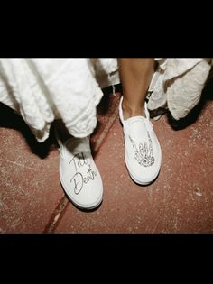 a person wearing white shoes with writing on them