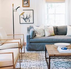 the living room is decorated in white and neutrals, including an antler's head