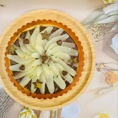 an overhead view of a pie with bananas in it on a wooden platter surrounded by flowers